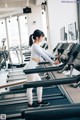 A woman running on a treadmill in a gym.