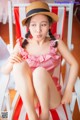 A woman in a red and white striped bathing suit sitting in a chair.