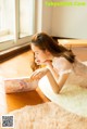 A woman laying on the floor reading a book.