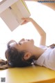 A woman laying on a table reading a book.