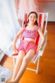 A woman sitting in a red and white striped chair.