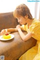 A woman sitting on a couch eating a piece of cake.