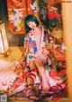 A woman in a colorful kimono sitting on the floor.