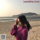 A woman standing on a beach next to the ocean.