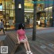 A woman sitting on a bench in front of a store.