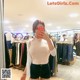 A woman taking a selfie in a clothing store.