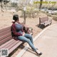 A woman sitting on a bench in a park.