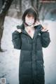 A woman wearing a face mask standing in the snow.