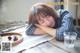 A woman laying on a table with her head on her hands.