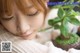 A woman laying on a bed next to a plant.