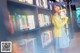 A woman standing in front of a bookshelf holding a book.