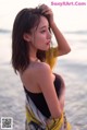 A woman standing on a beach next to the ocean.