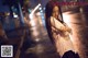 A woman standing in the middle of a street at night.