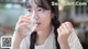 A woman drinking water from a glass in a restaurant.