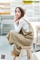 A woman sitting on a stool in a room.