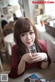 A woman sitting at a table with a glass of water.