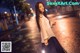 A woman holding a sparkler in the middle of a street.