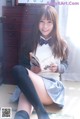 A young woman sitting on the floor reading a book.