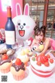 A little girl sitting at a table with a bunch of food.