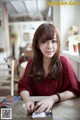 A woman sitting at a table with a book.