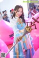 A woman in a blue and white dress holding a sword.