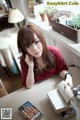 A woman sitting at a table with a book.