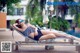 A woman in a black and white bathing suit laying on a lounge chair.