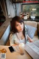 A woman sitting at a table with a cup of coffee.