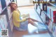 A woman sitting on the floor reading a book.