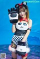 A woman dressed as a panda holding a stuffed animal.