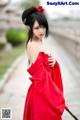 A woman in a red dress holding an umbrella.