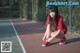 A woman tying up her shoes on a tennis court.