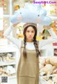 A woman holding up a stuffed cloud on her head.