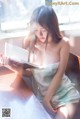 A woman sitting at a table reading a book.