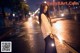 A woman standing in the middle of a street holding a sparkler.