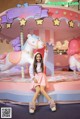 A young girl sitting on top of a carousel with a unicorn.