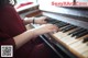 A woman is playing a piano with her hands on the keys.