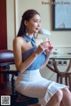 A woman sitting on a chair holding a glass of wine.