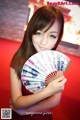 A woman in a red dress holding a fan.