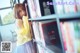 A young woman leaning against a bookshelf in a library.