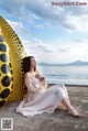 A woman sitting on the ground next to a yellow and black sculpture.