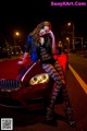 A woman sitting on top of a red sports car.