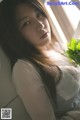 A woman laying on a window sill holding a bouquet of flowers.