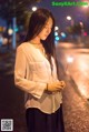 A woman holding a sparkler in the middle of a street.