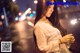 A woman holding a sparkler in her hand on a city street.