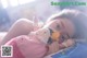 A young girl laying on a bed holding a stuffed animal.