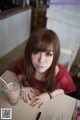 A woman sitting at a table with a cup of coffee.