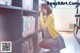 A woman crouching down in front of a bookshelf in a library.