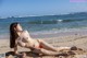 A woman in a bikini laying on the beach.