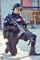 A woman in a military uniform holding a rifle.